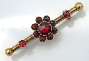 A garnet set yellow metal bar brooch bearing conti