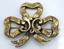 A 19thC. yellow metal bow brooch with chased decor