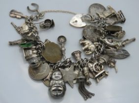 A silver charm bracelet including an Edwardian, 19