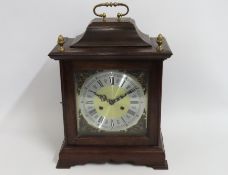 A bracket style clock with brass & silver coloured