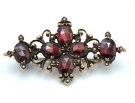 A yellow metal brooch set with garnet & pearl, som