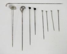 A selection of antique hat pins, some silver, long