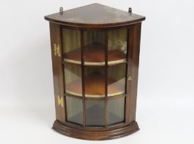 A glazed mahogany corner cabinet with brass fittin