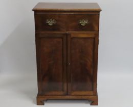 A mahogany drinks cabinet with fold back top, cupb