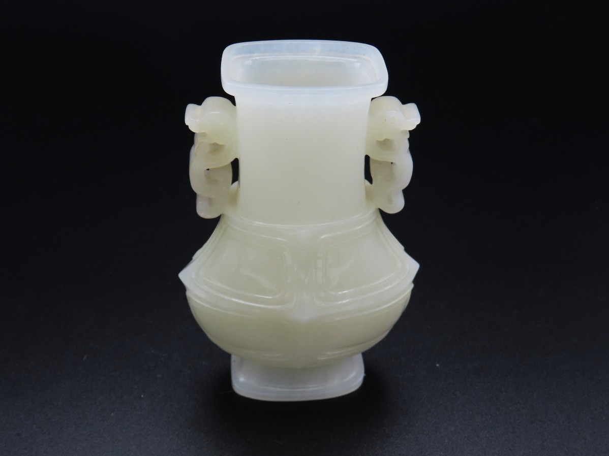 A Chinese pale jade vase with carved dragon handle