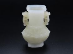 A Chinese pale jade vase with carved dragon handle