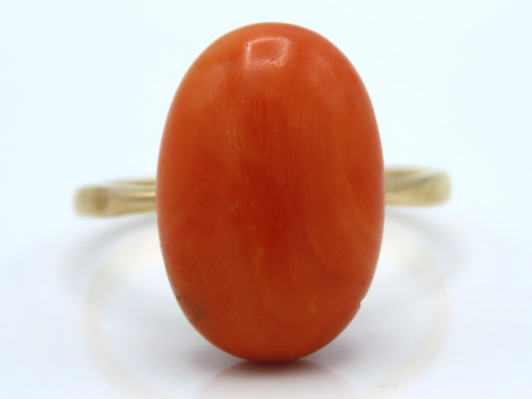 An antique 9ct gold ring set with coral, stone mea