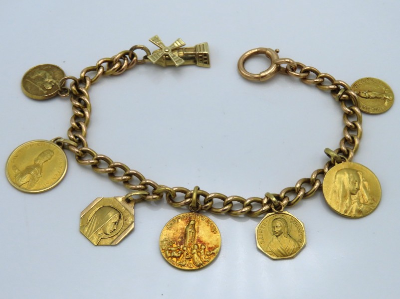 An 18ct gold chain with various Lourdes related ch