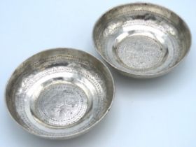 A pair of Islamic white metal dishes, test as silv
