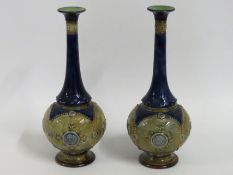 A pair of Doulton stoneware bottle vases with mask