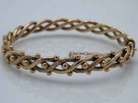 An antique 9ct gold bangle of decorative form with