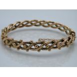 An antique 9ct gold bangle of decorative form with