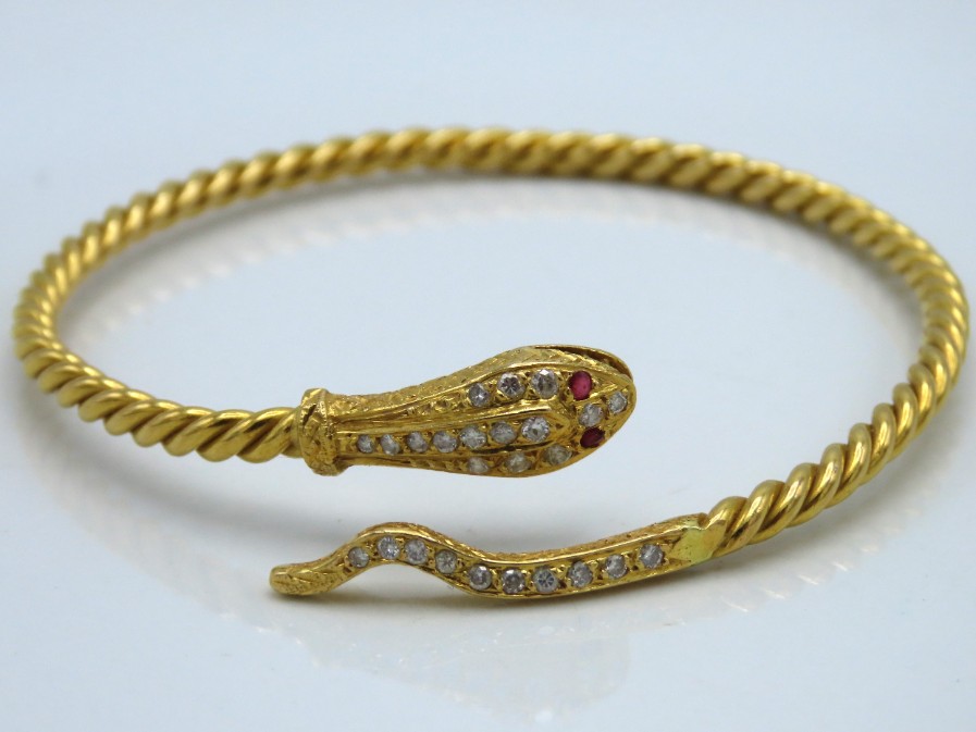 A yellow metal snake bangle, tests electronically
