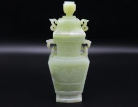 A carved Chinese jade vase with cover, depicting f