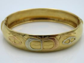 An 18ct three colour gold bangle, 25.1g, with plus