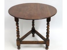 An antique oak cricket table with barley twist leg