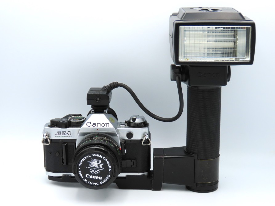 A Canon AE-1 Program 35mm film camera with a Canon FD 50mm lens & a Canon Speedlite 5770 flash, seri