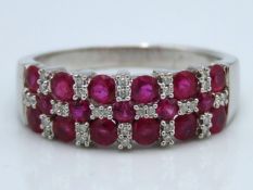 A white metal ring set with diamond & ruby, tests