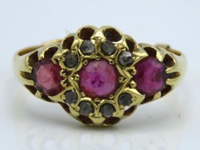 An antique yellow metal ring set with three rubies