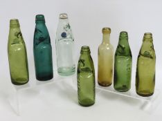 A collection of various colour seven codd bottles