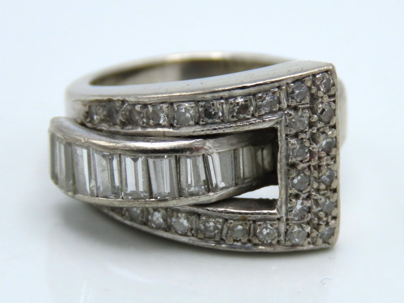A 14ct white gold buckle ring set with 28 round & 10 baguette diamonds, 7.7g, size H