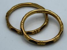 A pair of 14ct gold bands, encasing what appears t