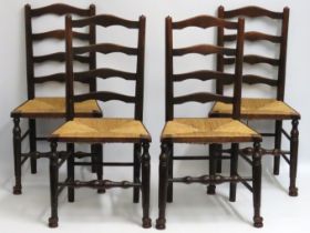 A set of four oak ladder back rush seated chairs,