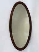 A mahogany framed tall oval mirror, 1160mm high x 540mm wide