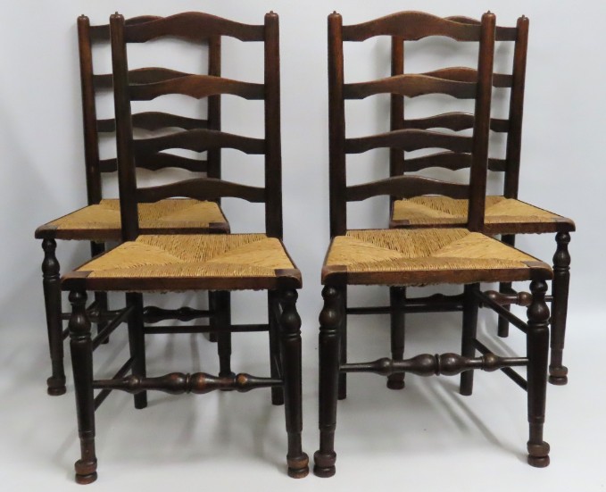 A set of four oak ladder back rush seated chairs,