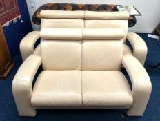 A contemporary, two piece cream leather suite, comprising of three & two seater sofas