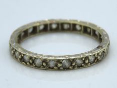 A white metal eternity ring tests as 9ct, set with white stones, 1.6g, size M/N