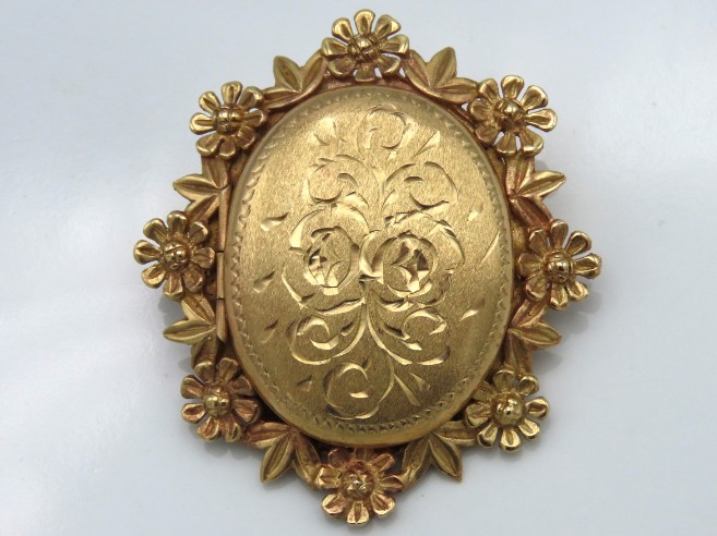 A good 9ct gold locket with floral & chased decor