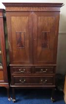 An antique mahogany cupboard with drawers under wi