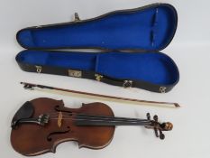 A cased violin with carved lions head to scroll wi