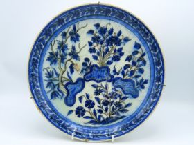 A 17thC. rimless Turkish Ottoman Iznik pottery dish with decorative floral sprays & footed base, fir