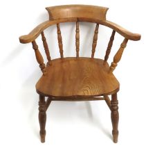 An antique, light elm smokers bow chair