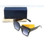 A boxed pair of Louis Vuitton sunglasses with soft