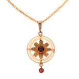 Pendant depicting a flower with two faceted red stones