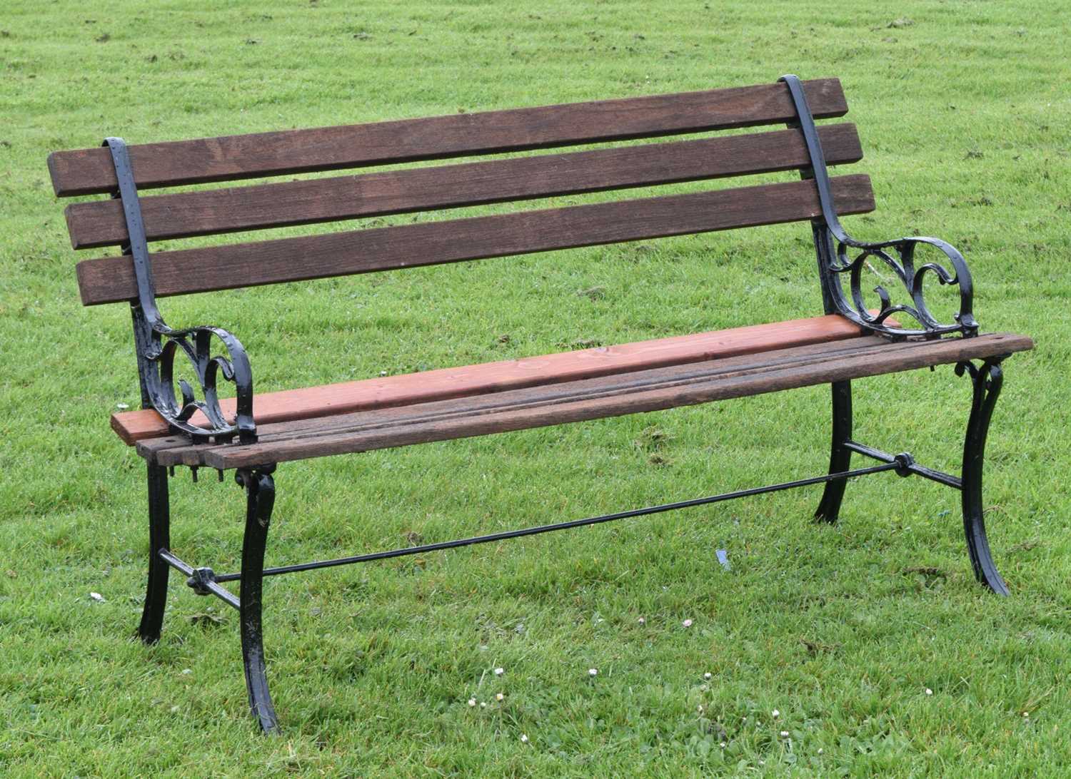 Modern two seater teak garden bench with cast metal ends