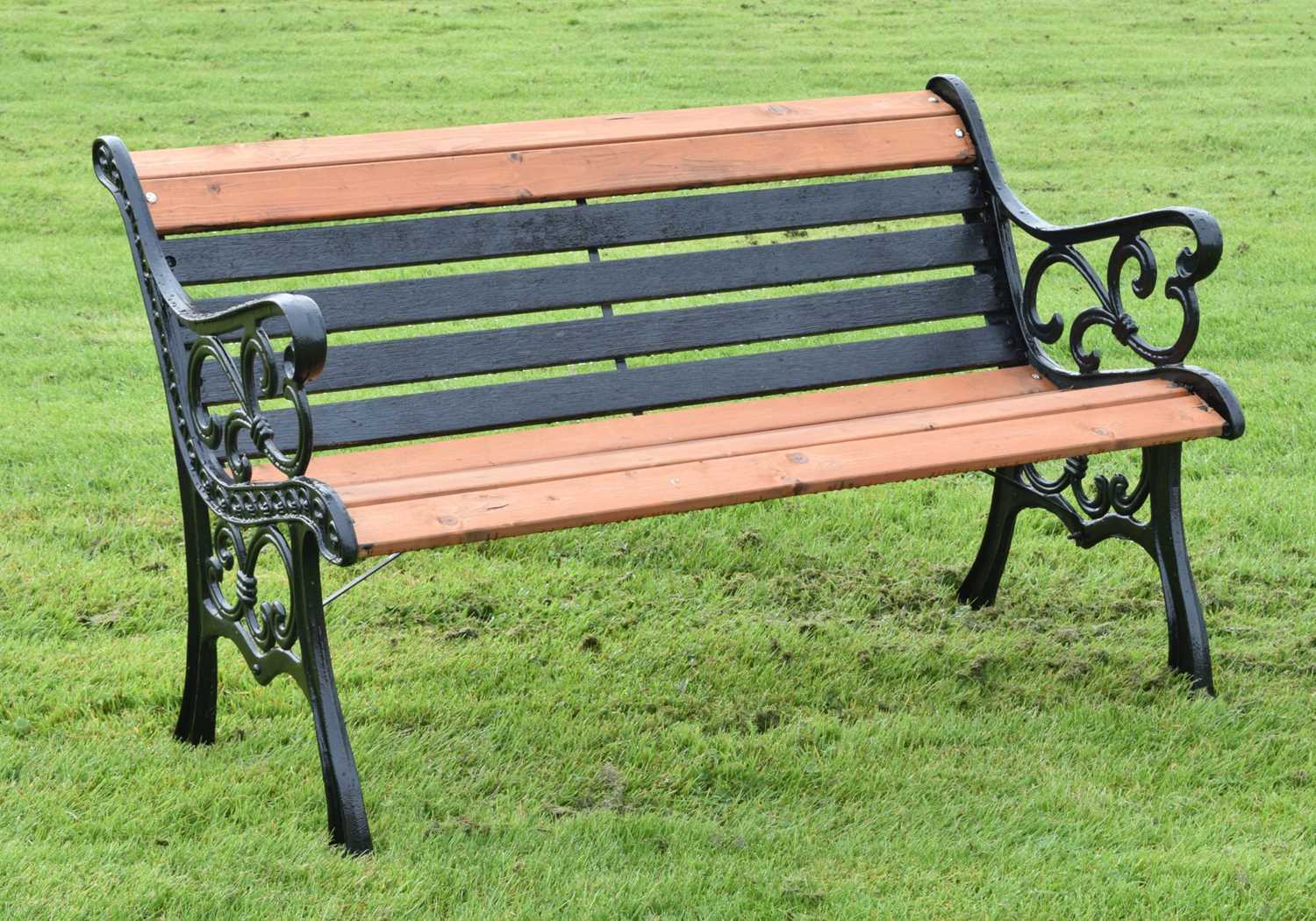 Modern two seater teak garden bench with cast metal ends