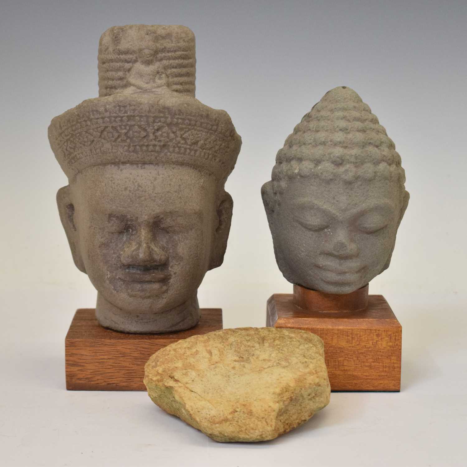 Two South East Asian grey stone busts and a carved stone fragment