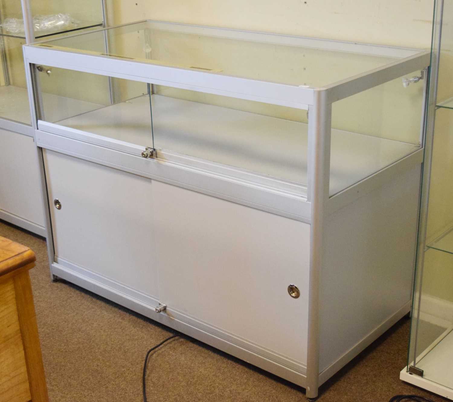 Modern glazed panelled and metal framed shop display low cabinet