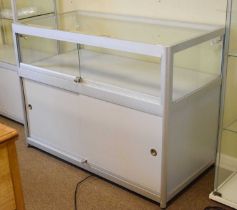 Modern glazed panelled and metal framed shop display low cabinet