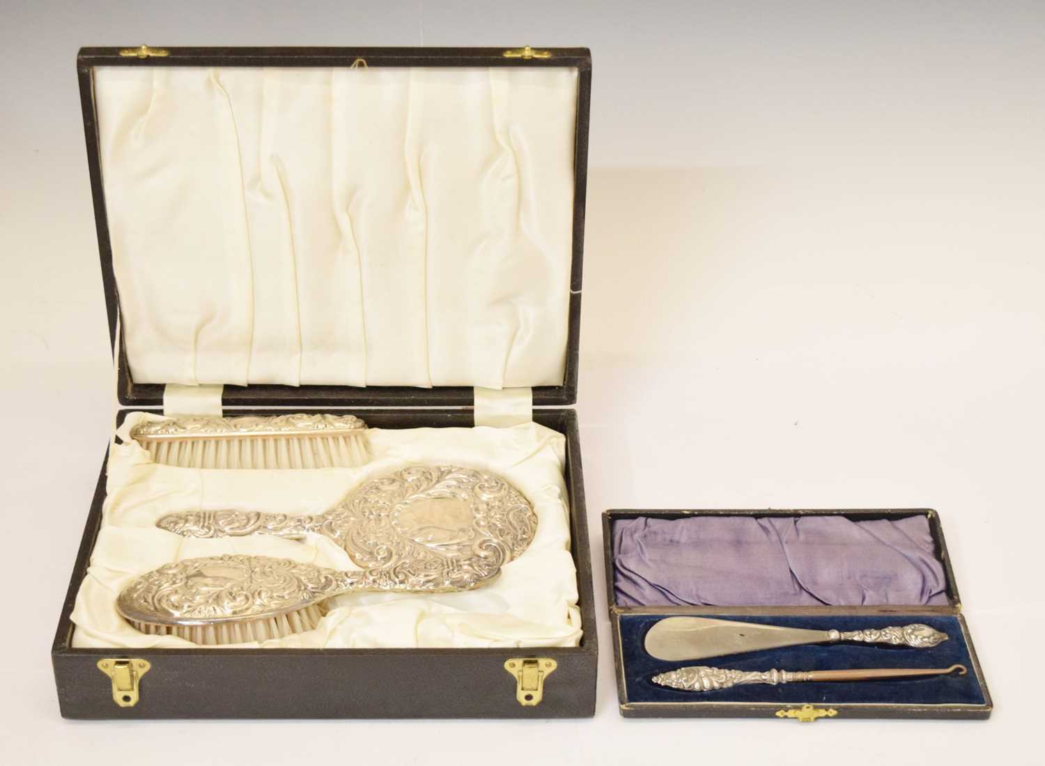 Cased Elizabeth II silver-backed dressing table set, and a silver handled shoe horn and button hook