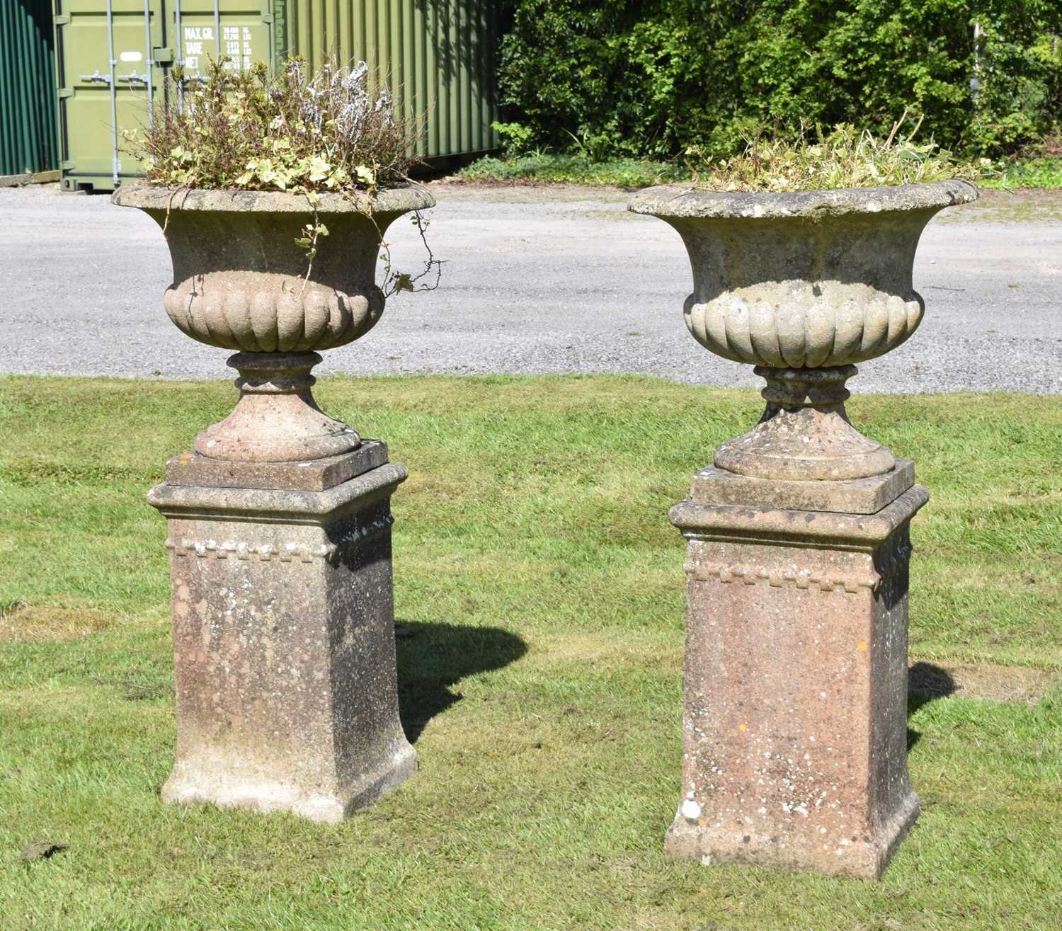 Pair of composition stone garden urns and pedestals