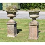 Pair of composition stone garden urns and pedestals