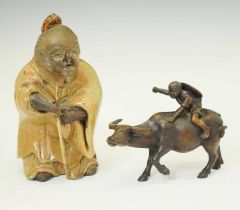 Japanese pottery figure of a gentleman and a resin figure of a boy on buffalo