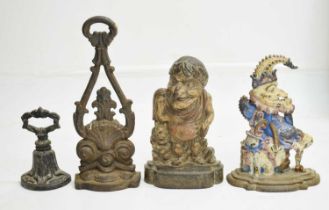 Two early 20th century cast iron Mr Punch doorstops and two other