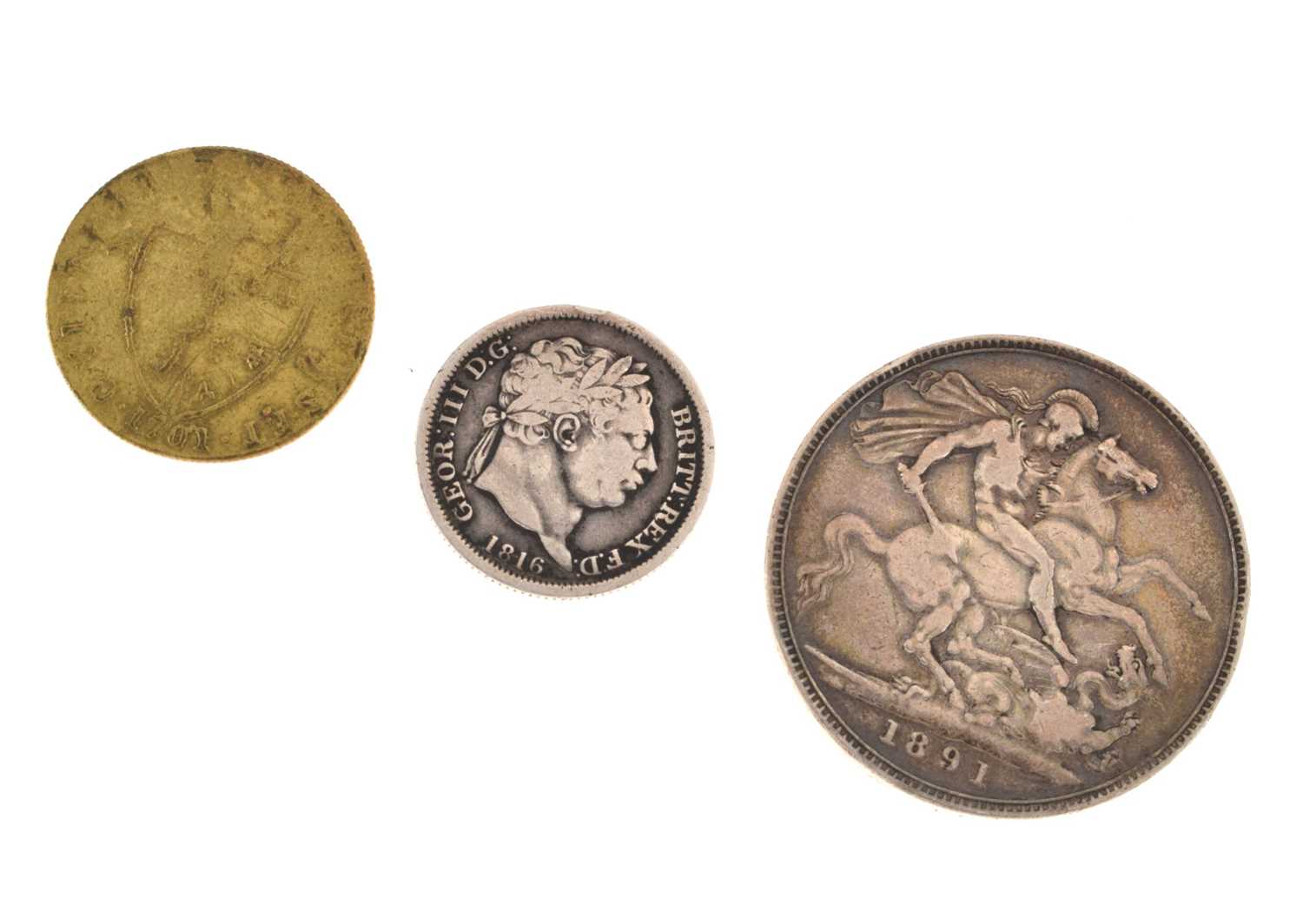 Victorian silver crown, George III shilling, and a Georgian gilt gaming counter