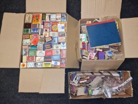 Three boxes containing a large collection of vintage match book covers and matchboxes.